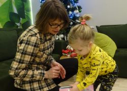 Mała dziewczynka otwiera świąteczny prezent