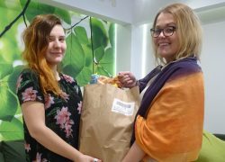 Nasza podopieczna odbiera paczkę z żywnością od asystentki usamodzielniania