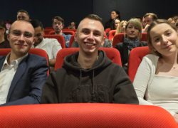 Uśmiechnięci młodzi ludzie na sali teatralnej