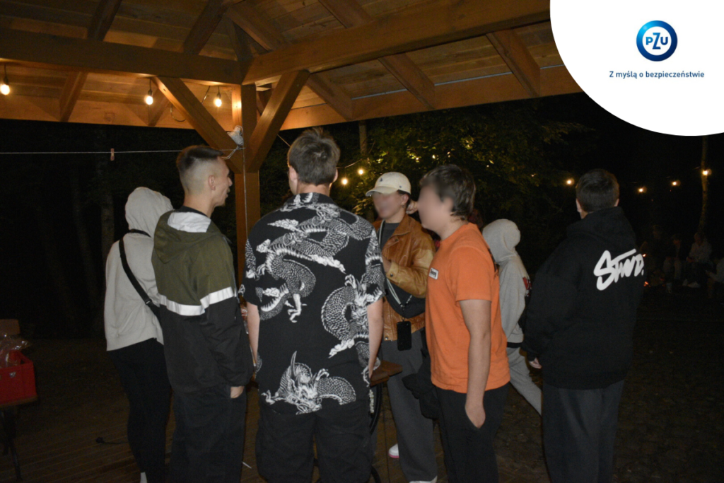 Grupka młodych ludzi stoi w okręgu rozmawiając